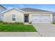 Charming single-story home featuring a well-maintained lawn, attached garage and neutral stucco at 1371 Madison Cir, Haines City, FL 33844