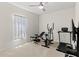 Home gym complete with weight bench, elliptical, treadmill, and light streaming through the window at 1371 Madison Cir, Haines City, FL 33844