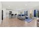 Bright open-plan living area featuring tile flooring, a stylish grey sofa and granite countertops at 1371 Madison Cir, Haines City, FL 33844