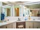 Well-lit bathroom featuring dual sinks, three vanity mirrors, and ample counter space and a convenient stool at 1610 Reynolds Rd # 204, Lakeland, FL 33801