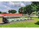 Exterior view of shuffleboard courts surrounded by lush green grass, tall trees, and seating benches at 1610 Reynolds Rd # 204, Lakeland, FL 33801