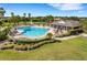 Aerial view of a beautiful pool area with a lap pool, lounge chairs, umbrellas, and tropical landscaping at 1739 Laurel Glen Pl, Lakeland, FL 33803