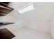 A clean attic space is shown with white floors and walls and dark shelves for storage at 1739 Laurel Glen Pl, Lakeland, FL 33803