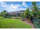 Well-maintained backyard with green grass, trees, garden, and an enclosed patio with a swimming pool at 1739 Laurel Glen Pl, Lakeland, FL 33803