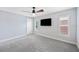 An inviting bedroom with neutral walls, plush carpeting, a ceiling fan, and a wall-mounted TV offers a relaxing retreat at 1739 Laurel Glen Pl, Lakeland, FL 33803