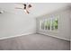 Spacious bedroom with a ceiling fan, large window, and neutral carpet at 1739 Laurel Glen Pl, Lakeland, FL 33803