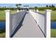 Bridge with white railings overlooking a pond and green lawns with mature trees and blue skies overhead at 1739 Laurel Glen Pl, Lakeland, FL 33803