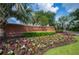 Community entrance with brick wall, decorative landscaping, and abundant seasonal flowers at 1739 Laurel Glen Pl, Lakeland, FL 33803