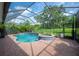 Enclosed pool and spa featuring a brick deck and a lovely view of the yard and garden at 1739 Laurel Glen Pl, Lakeland, FL 33803