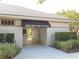 Building entrance with 'Deck Side Pool & Tennis' sign, bushes, and a glimpse of the pool area inside at 1739 Laurel Glen Pl, Lakeland, FL 33803