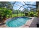 Enclosed pool and spa featuring tiled accents and a lovely view of the yard and garden at 1739 Laurel Glen Pl, Lakeland, FL 33803
