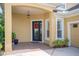Inviting front porch with stylish black door adorned with a festive wreath, and decorative plants at 1739 Laurel Glen Pl, Lakeland, FL 33803