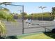 People playing tennis at a community court with a net, fence, and surrounded by lush tropical landscaping at 1739 Laurel Glen Pl, Lakeland, FL 33803