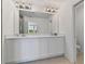 Modern bathroom with double vanity, white cabinetry, and large mirrors at 1754 Sanibel Dr, Davenport, FL 33896