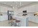 A modern kitchen with white cabinets, stainless steel appliances, and an island with barstools at 1754 Sanibel Dr, Davenport, FL 33896