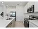 An open-concept kitchen featuring white cabinetry, stainless steel appliances, and a quartz countertop island at 1754 Sanibel Dr, Davenport, FL 33896