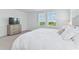 Bright primary bedroom with large bed, soft carpet, view filled windows, and neutral palette at 1754 Sanibel Dr, Davenport, FL 33896