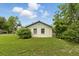 View of the back exterior of the home with a grassy yard and trees at 1820 Salem Rd, Lakeland, FL 33803