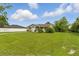 Cozy single-story house with a well-manicured lawn, complemented by lush greenery and blue skies at 1820 Salem Rd, Lakeland, FL 33803