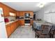 Functional kitchen with wooden cabinetry, appliances, and an adjacent dining area with table and chairs at 1823 Blue Lake Dr, Lakeland, FL 33801