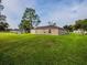 Spacious backyard with verdant lawn and a view of the home's exterior at 1824 Baltic Pl, Lakeland, FL 33809