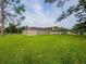 Expansive backyard featuring lush green grass and view of the home's exterior at 1824 Baltic Pl, Lakeland, FL 33809