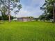 View of a single-story home from the grassy backyard on a sunny day at 1824 Baltic Pl, Lakeland, FL 33809