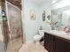 Well-lit bathroom featuring a tiled walk-in shower, vanity with sink, and toilet at 1824 Baltic Pl, Lakeland, FL 33809