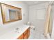 Traditional bathroom with wood vanity, white tile floor, and shower-tub combo at 1917 Lori W Ln, Lakeland, FL 33801