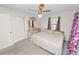Bedroom features large bed, two windows with floral curtains, and neutral carpeting at 1917 Lori W Ln, Lakeland, FL 33801