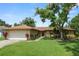 Charming single-story home with a well-manicured lawn and mature landscaping at 1917 Lori W Ln, Lakeland, FL 33801