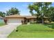 Charming single-story home with a well-manicured lawn and mature landscaping at 1917 Lori W Ln, Lakeland, FL 33801