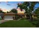 Charming one-story home featuring a well-manicured lawn, mature tree, and attached two-car garage at 1917 Lori W Ln, Lakeland, FL 33801