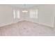 Bright living room features mauve carpet and large windows that let in plenty of natural light at 1917 Lori W Ln, Lakeland, FL 33801