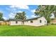 View of a white home with a green lawn, small mulch beds, and partial fencing at 1920 Kimball S Ct, Lakeland, FL 33813