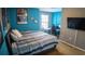 Comfortable bedroom featuring blue accent walls, a well-lit workspace, and a large-screen TV for entertainment at 2170 Forest Lake Ave, Dundee, FL 33838