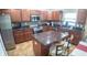 Spacious kitchen featuring stainless appliances, dark wood cabinets, granite counters and central island at 2170 Forest Lake Ave, Dundee, FL 33838