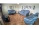 Inviting living room with tile flooring and neutral wall paint. Three chairs are spread out across the room at 2170 Forest Lake Ave, Dundee, FL 33838
