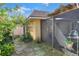 View of the property's yard and screen-enclosed patio area with adjacent flowering bushes at 2203 Starboard, Winter Haven, FL 33881
