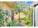 Fenced backyard with metal trellis, lush greenery, and decorative plantings at 2203 Starboard, Winter Haven, FL 33881