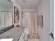 Bathroom with neutral shower curtain, granite countertop, and palm tree art at 2244 Teneroc Trl, Lakeland, FL 33801