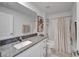 Bathroom featuring granite countertop, palm tree art, and neutral shower curtain at 2244 Teneroc Trl, Lakeland, FL 33801