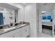 Bright bathroom with granite countertop and double sink vanity next to open bedroom at 2244 Teneroc Trl, Lakeland, FL 33801