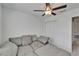 Carpeted bedroom offers a large, comfortable sofa and a ceiling fan for a relaxing space at 2244 Teneroc Trl, Lakeland, FL 33801