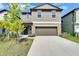 Two-story home with neutral siding, a two-car garage, and a well-maintained lawn at 2244 Teneroc Trl, Lakeland, FL 33801