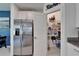 Pantry with organized shelving, stainless steel refrigerator and access to dining area at 2244 Teneroc Trl, Lakeland, FL 33801