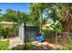 Backyard featuring a storage shed, lush greenery, and a wheelbarrow at 2632 Handley Blvd, Lakeland, FL 33803