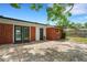 Paver patio, red brick exterior, double french doors and manicured lawn in backyard at 2632 Handley Blvd, Lakeland, FL 33803