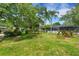 Manicured backyard with mature trees, landscaping, and an in ground pool with a screen enclosure at 2632 Handley Blvd, Lakeland, FL 33803