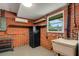 Unfinished basement featuring exposed brick walls, utility sink, and a small refrigerator at 2632 Handley Blvd, Lakeland, FL 33803